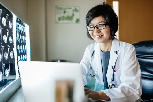 Radiologist analysing medical scans on a computer.